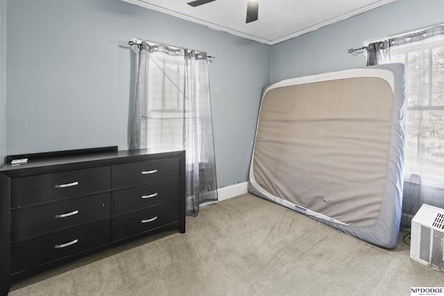 carpeted bedroom with ceiling fan and crown molding