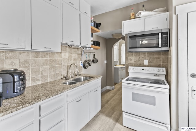 kitchen with white cabinetry, white electric range, light hardwood / wood-style flooring, light stone counters, and sink