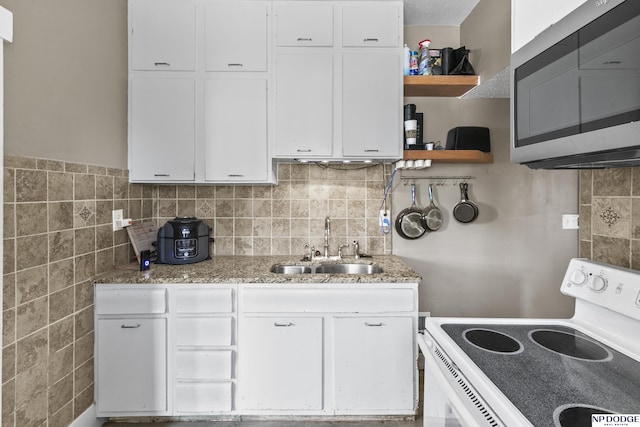 kitchen with backsplash, white range with electric stovetop, stone counters, sink, and white cabinetry