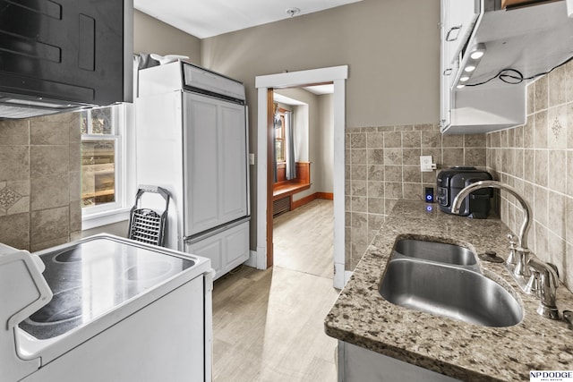 kitchen featuring light hardwood / wood-style floors, light stone counters, white range with electric cooktop, and sink