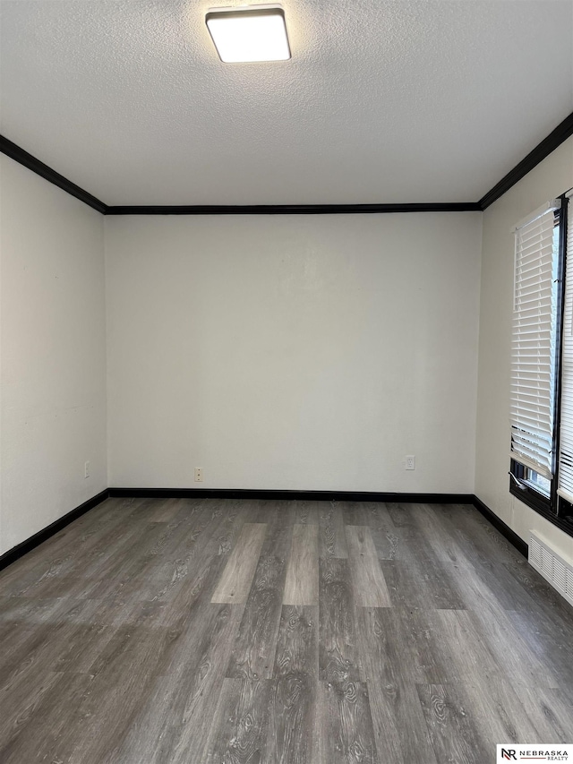 unfurnished room featuring a textured ceiling, crown molding, and dark hardwood / wood-style floors