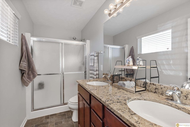 bathroom with toilet, walk in shower, and vanity