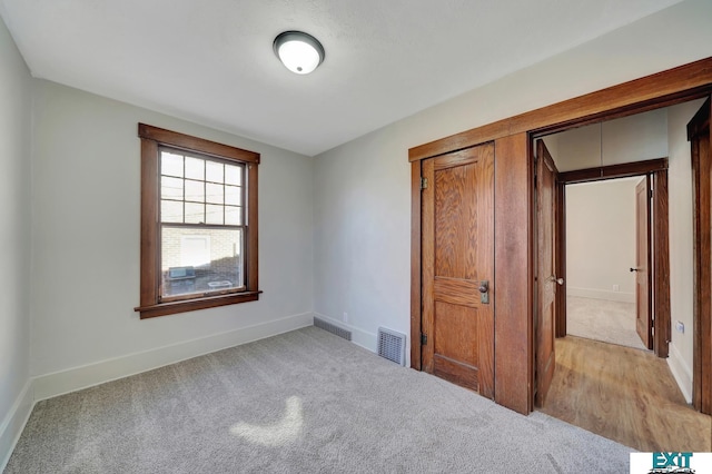 unfurnished bedroom featuring light carpet