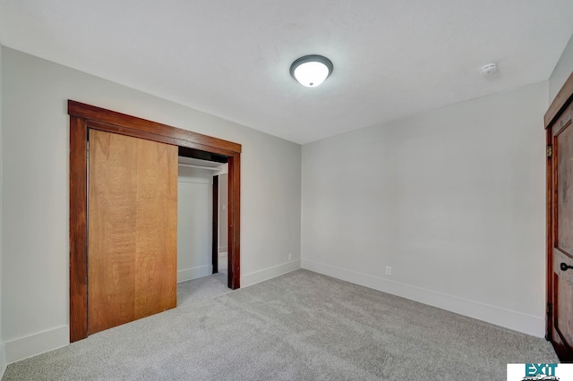 unfurnished bedroom featuring light colored carpet and a closet