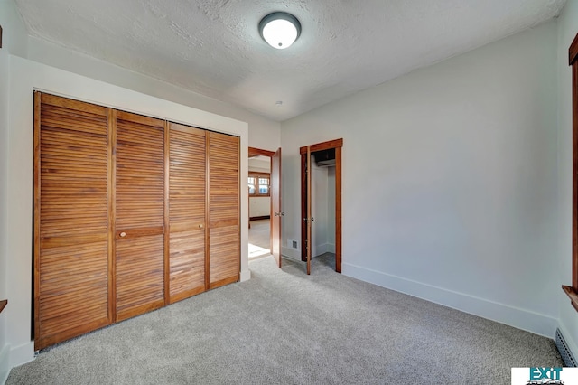 unfurnished bedroom featuring carpet, a closet, and a textured ceiling