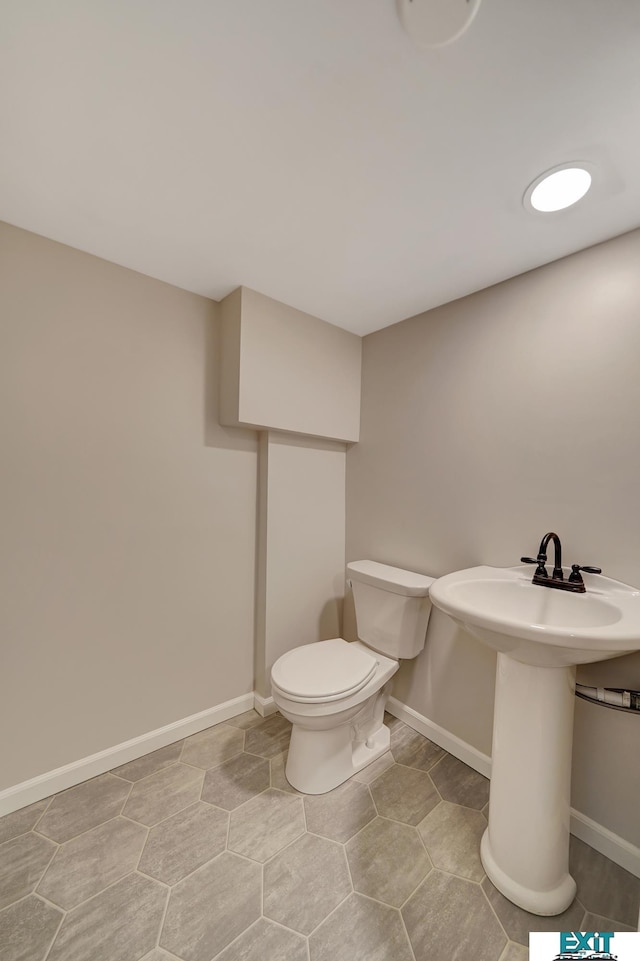 bathroom featuring toilet, tile patterned flooring, and sink