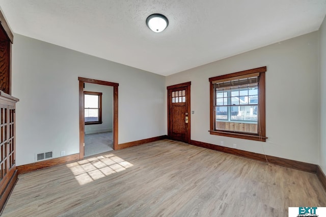 foyer with light hardwood / wood-style floors and a textured ceiling