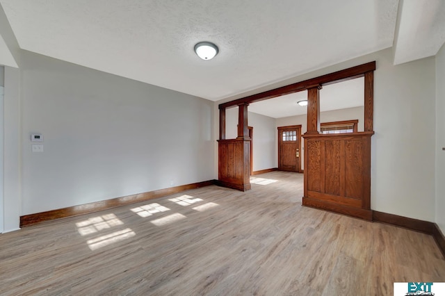 spare room featuring a textured ceiling and light hardwood / wood-style flooring