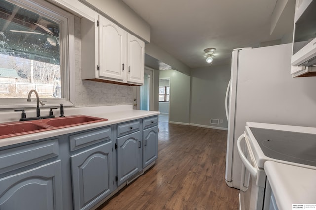 kitchen with white cabinetry, dark hardwood / wood-style flooring, decorative backsplash, sink, and electric range