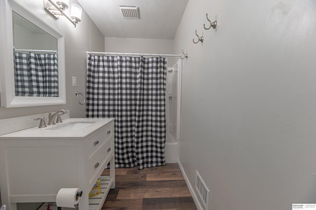 bathroom featuring shower / bathtub combination with curtain, hardwood / wood-style floors, and vanity