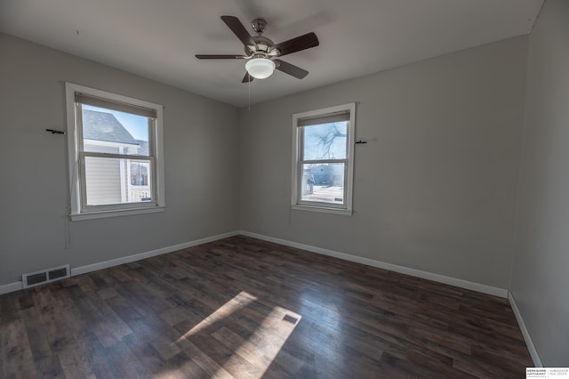 spare room with dark wood-type flooring and ceiling fan