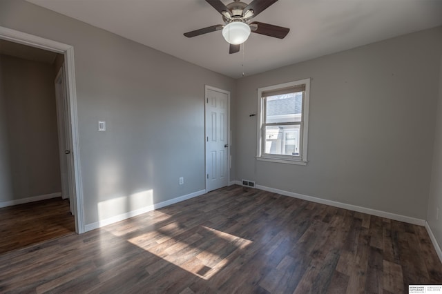 unfurnished room featuring ceiling fan and dark wood-type flooring