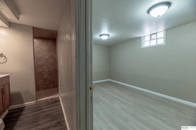 bathroom featuring wood-type flooring, walk in shower, and vanity