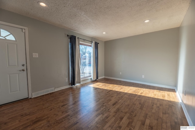 foyer with dark wood-type flooring and a textured ceiling