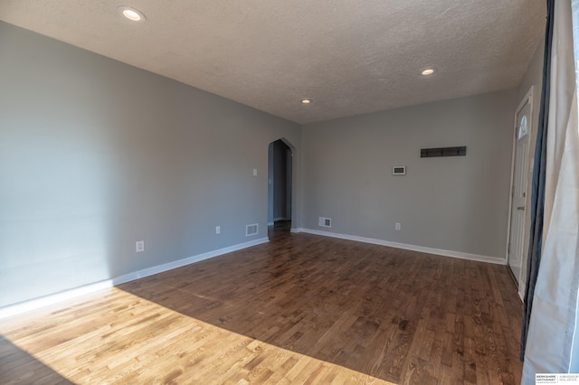 unfurnished room featuring wood-type flooring and a textured ceiling