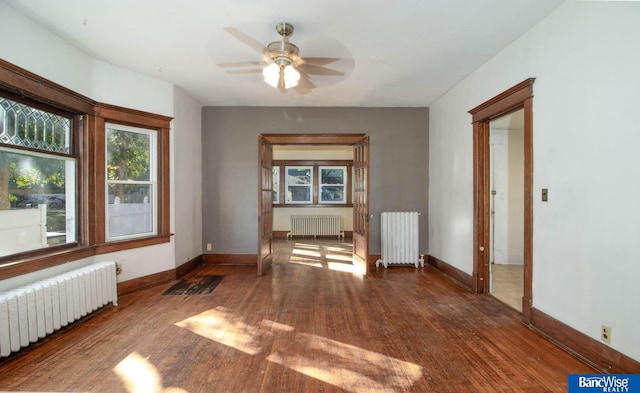 unfurnished room featuring ceiling fan, dark hardwood / wood-style flooring, and radiator heating unit