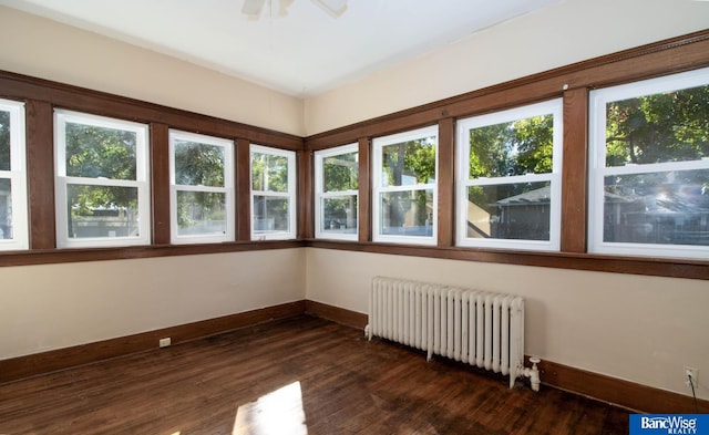 unfurnished sunroom featuring ceiling fan and radiator heating unit