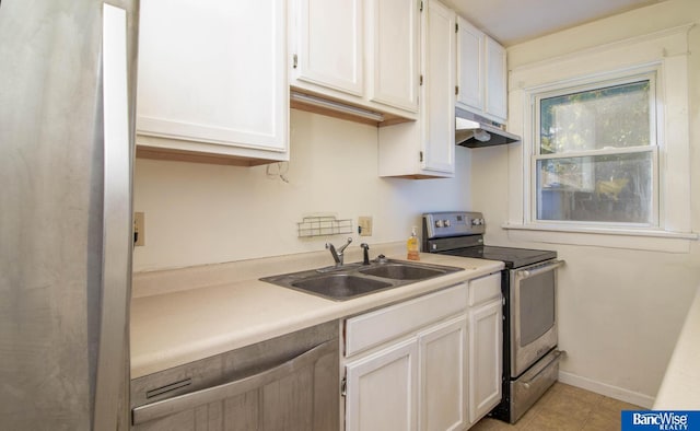 kitchen with stainless steel range with electric stovetop, white cabinetry, and sink