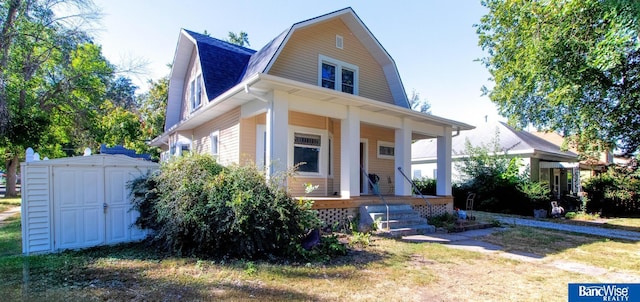 view of front facade with covered porch and a shed