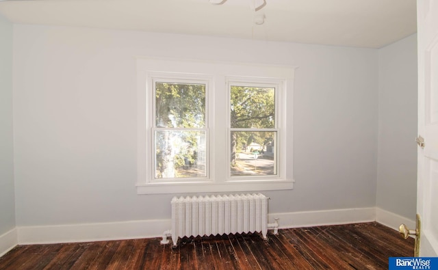 empty room with radiator and dark hardwood / wood-style floors