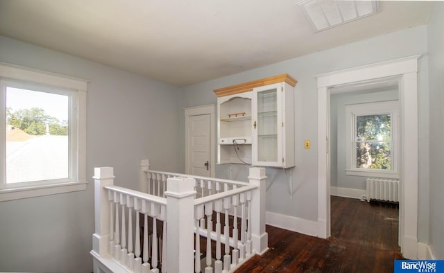 bedroom with radiator, dark hardwood / wood-style floors, and a nursery area