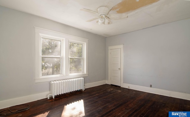 empty room with ceiling fan, radiator heating unit, and dark hardwood / wood-style flooring