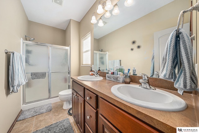 bathroom with toilet, vanity, tile patterned floors, and a shower with door