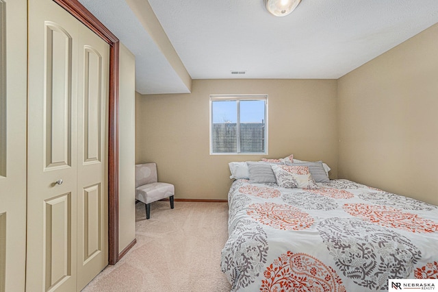 bedroom with light carpet and a closet