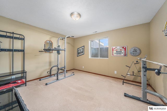 exercise area with a textured ceiling and light carpet