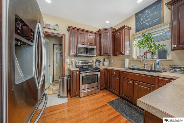 kitchen featuring sink, appliances with stainless steel finishes, and light wood-type flooring