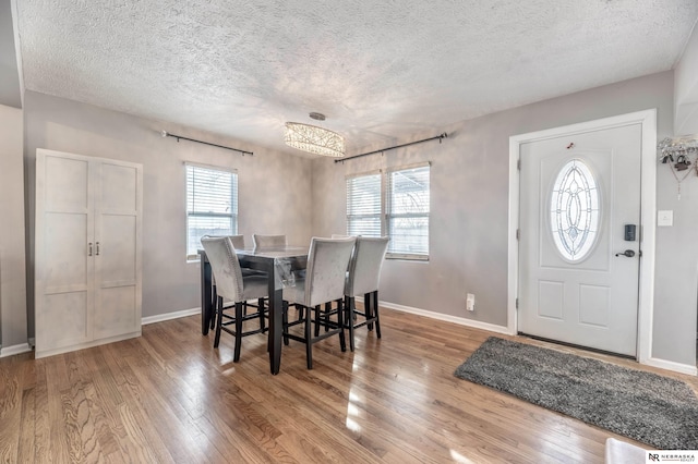 dining space featuring a textured ceiling and hardwood / wood-style floors