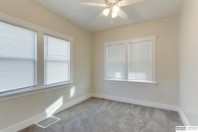 spare room with ceiling fan and light colored carpet