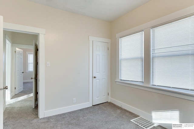 unfurnished bedroom featuring light colored carpet and a closet