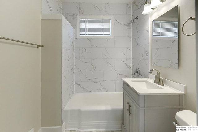 full bathroom featuring toilet, tiled shower / bath combo, and vanity