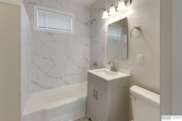 full bathroom with toilet, tiled shower / bath, and vanity