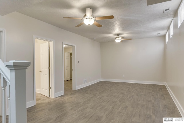 spare room featuring a textured ceiling and hardwood / wood-style flooring