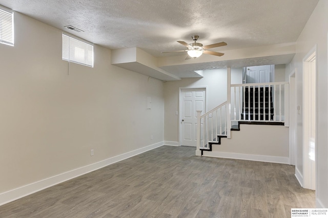 basement featuring ceiling fan, a textured ceiling, and hardwood / wood-style flooring