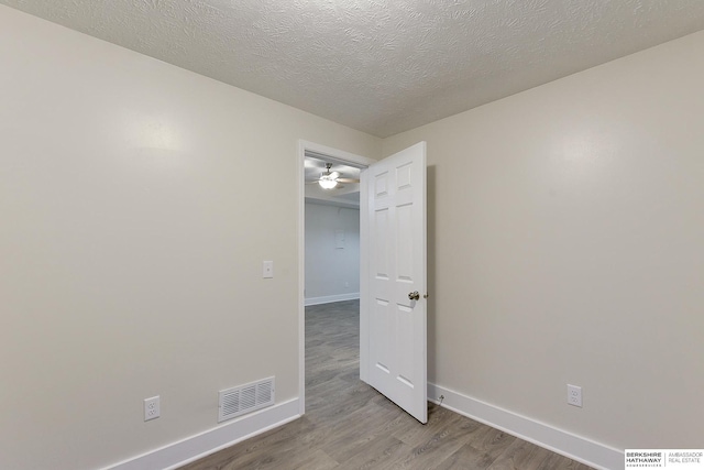 unfurnished room with light hardwood / wood-style floors and a textured ceiling