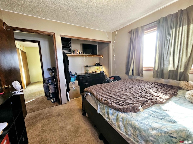 bedroom featuring carpet floors, a closet, and a textured ceiling