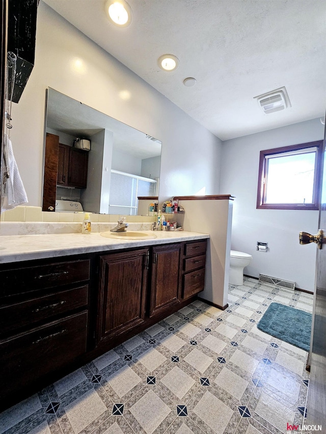 bathroom with vanity, toilet, and an enclosed shower