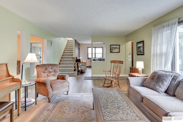 living room with light hardwood / wood-style floors and a textured ceiling