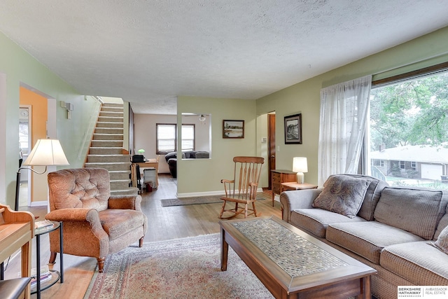 living room with a textured ceiling and light hardwood / wood-style flooring