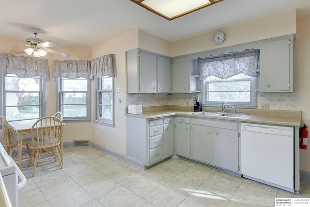 kitchen featuring gray cabinets, ceiling fan, backsplash, white dishwasher, and sink