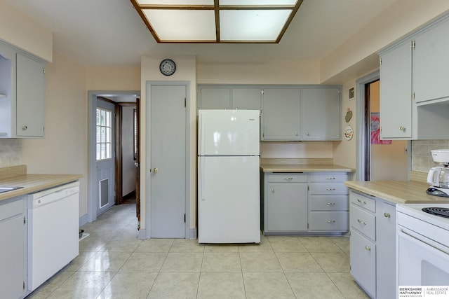 kitchen featuring decorative backsplash, white appliances, gray cabinets, and light tile patterned flooring