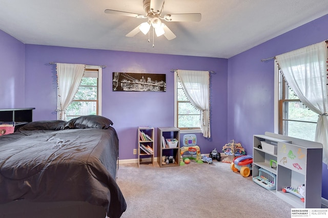 carpeted bedroom with ceiling fan and multiple windows