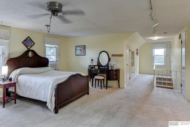 bedroom featuring ceiling fan, rail lighting, cooling unit, and light carpet