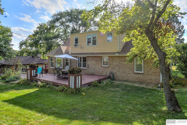 rear view of property with a deck and a yard