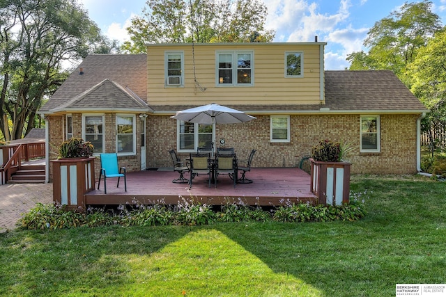 back of property with a wooden deck and a lawn