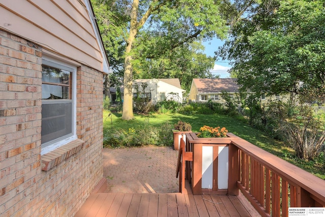 wooden terrace with a lawn and a patio