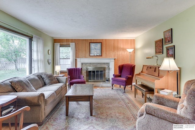 living room with a textured ceiling, hardwood / wood-style floors, and wooden walls